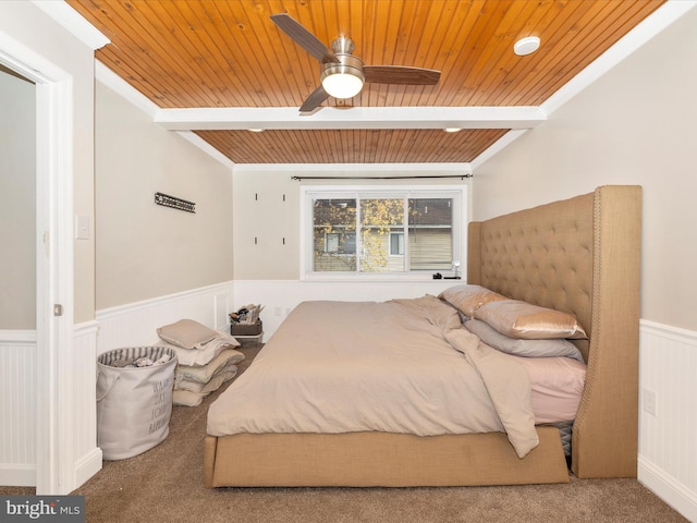 bedroom with carpet, wooden ceiling, ceiling fan, ornamental molding, and beamed ceiling