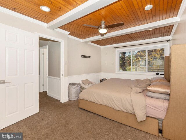 carpeted bedroom featuring beam ceiling, ceiling fan, crown molding, and wooden ceiling