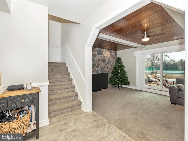 interior space featuring ceiling fan, a fireplace, carpet, and wooden ceiling