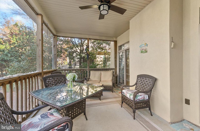 sunroom featuring ceiling fan and wood ceiling