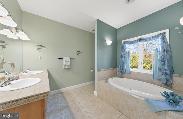 bathroom with tile patterned flooring, vanity, and tiled bath