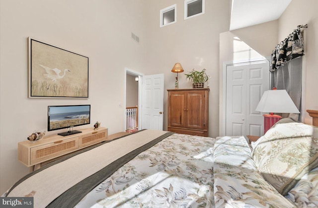 bedroom with a high ceiling and a closet