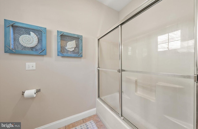 bathroom featuring tile patterned floors and bath / shower combo with glass door