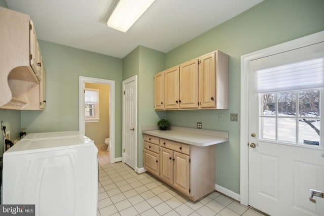 laundry room featuring washer / dryer, cabinets, light tile patterned floors, and a healthy amount of sunlight