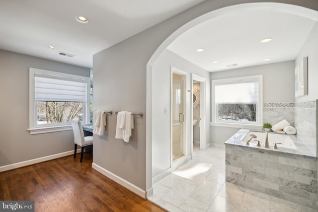 bathroom with hardwood / wood-style floors and tiled tub