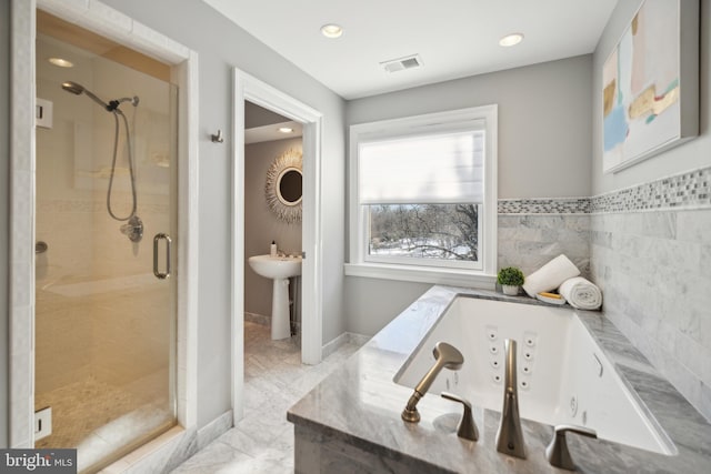 bathroom featuring separate shower and tub and tile walls