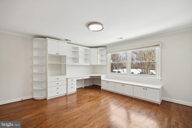 unfurnished office featuring dark hardwood / wood-style flooring, crown molding, and built in desk