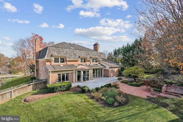 back of house with a patio area and a lawn