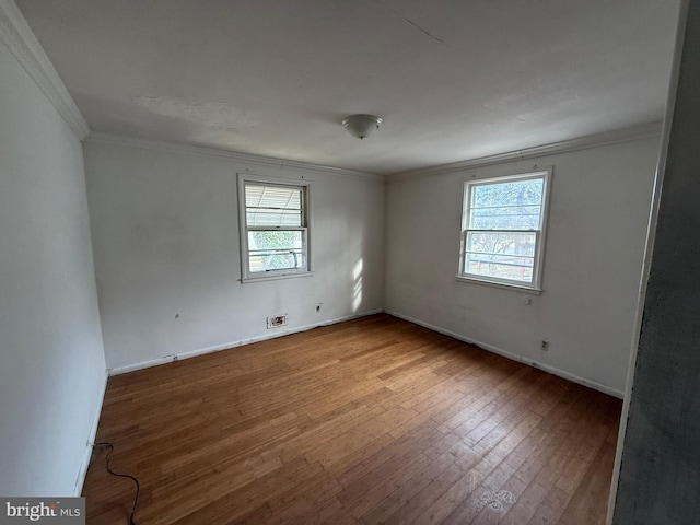 empty room featuring hardwood / wood-style flooring and ornamental molding