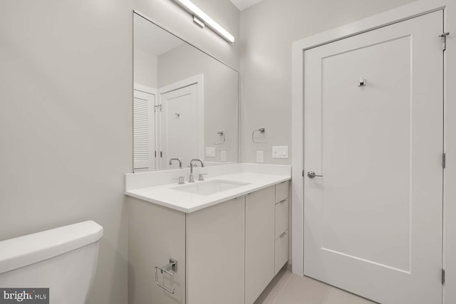 bathroom featuring tile patterned flooring, vanity, and toilet