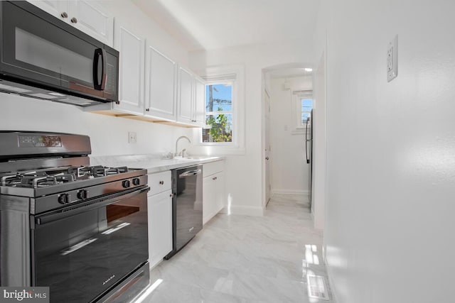 kitchen with white cabinetry, sink, range with gas stovetop, and stainless steel dishwasher