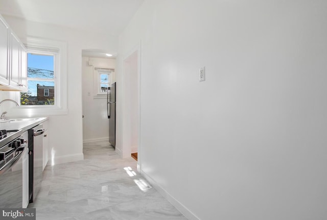 3917 Ridgewood Ave, Baltimore, MD 21215 - hall with a sink, baseboards, light marble finish flooring, and arched walkways