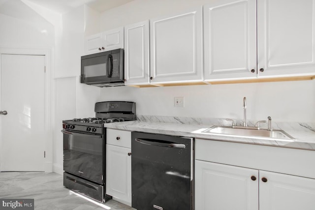 kitchen featuring sink, light stone counters, white cabinetry, and black appliances