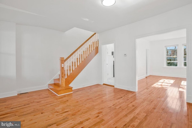 3917 Ridgewood Ave, Baltimore, MD 21215 - unfurnished living room featuring light wood-style flooring, stairs, and baseboards