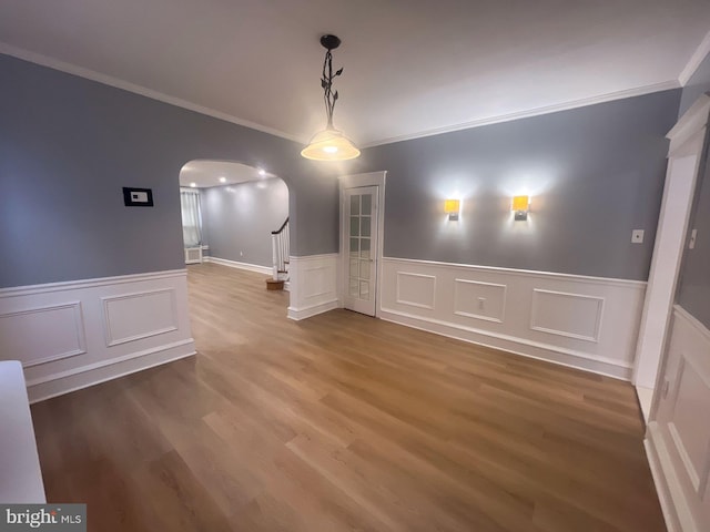 unfurnished dining area featuring hardwood / wood-style floors and crown molding