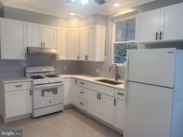 kitchen with white appliances, sink, ceiling fan, ornamental molding, and white cabinetry