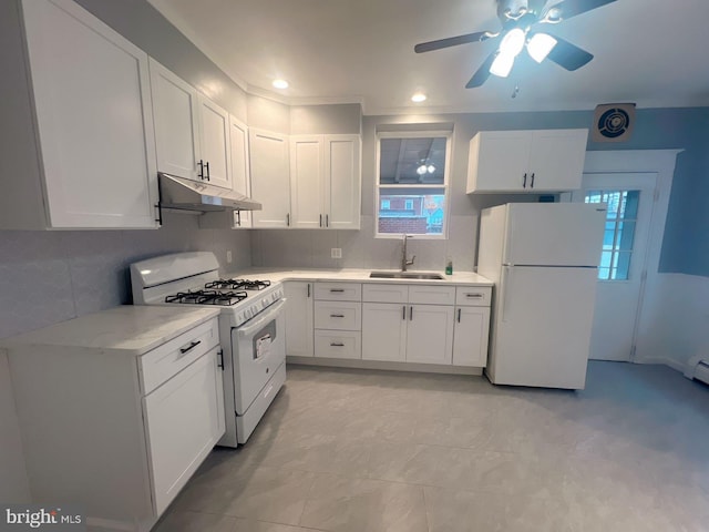 kitchen featuring decorative backsplash, sink, white cabinets, and white appliances