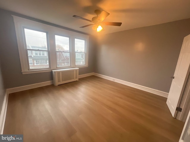 interior space featuring hardwood / wood-style floors, radiator, and ceiling fan