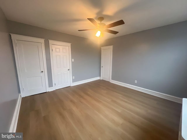 unfurnished bedroom featuring wood-type flooring and ceiling fan