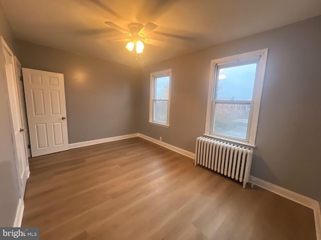 interior space featuring hardwood / wood-style floors, ceiling fan, and radiator