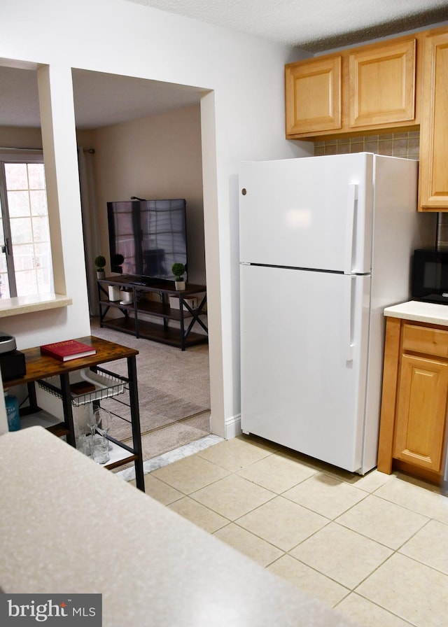 kitchen with light tile patterned flooring and white refrigerator