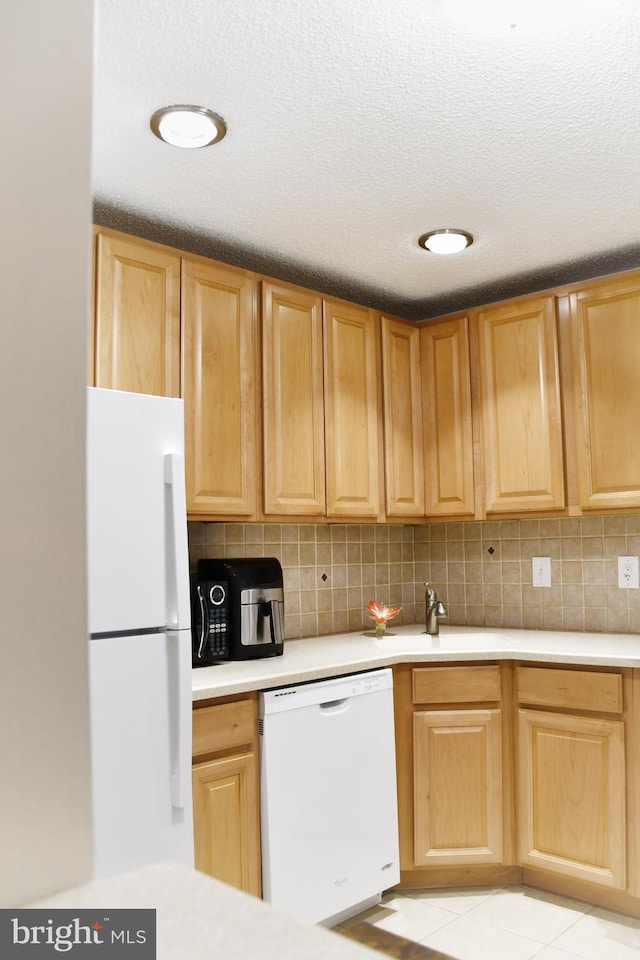 kitchen with decorative backsplash, white appliances, sink, and light tile patterned floors