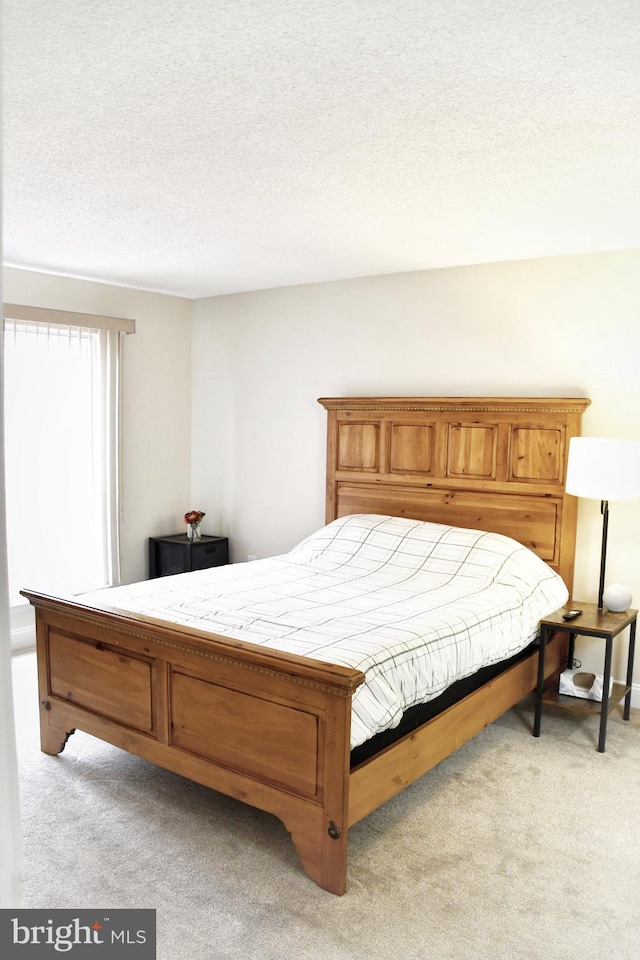 carpeted bedroom featuring a textured ceiling