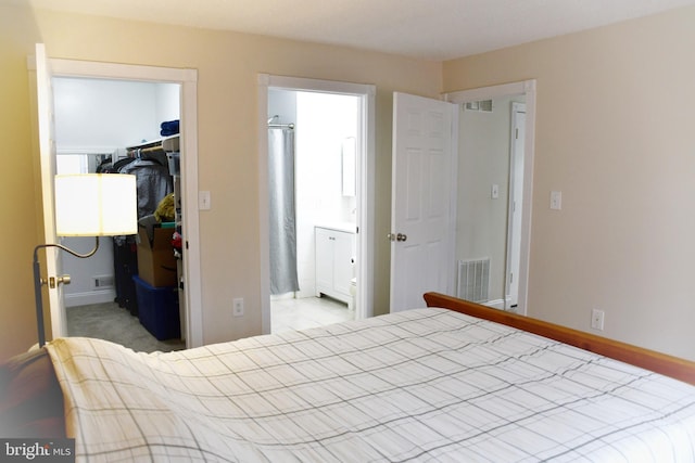 bedroom with a spacious closet, a closet, and light colored carpet