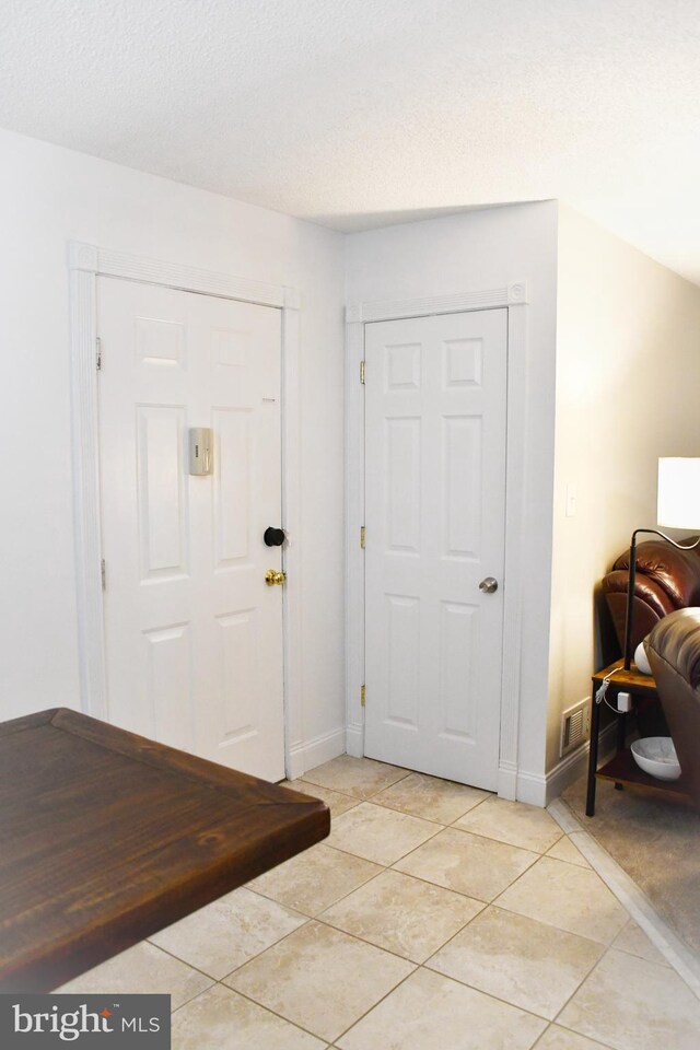 tiled foyer entrance featuring a textured ceiling