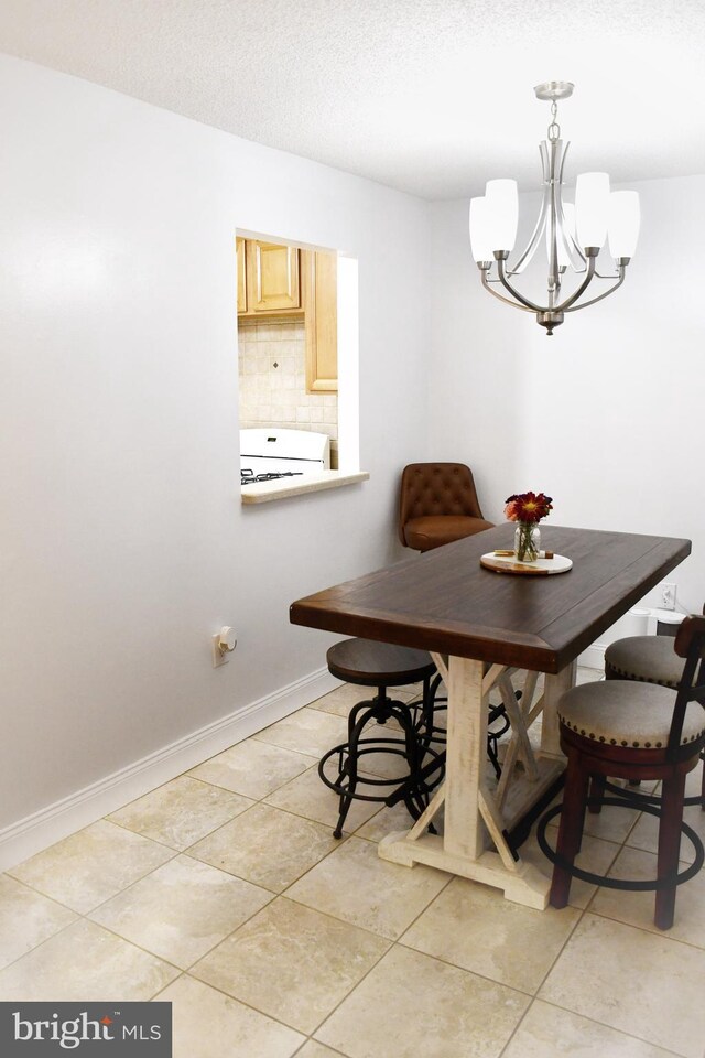 tiled dining area featuring an inviting chandelier