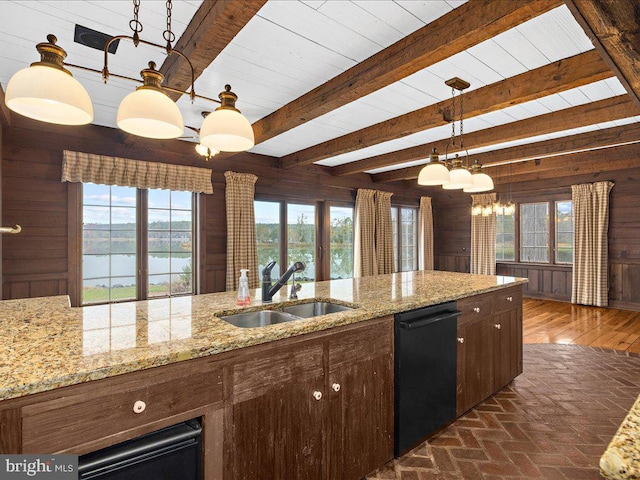 kitchen featuring dishwasher, wooden walls, sink, and a water view