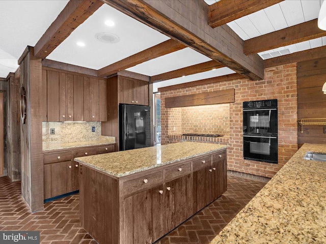 kitchen featuring a center island, black appliances, light stone countertops, tasteful backsplash, and beamed ceiling