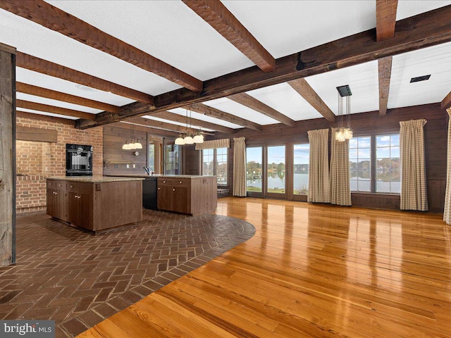 kitchen with black appliances, a notable chandelier, a center island, and hanging light fixtures