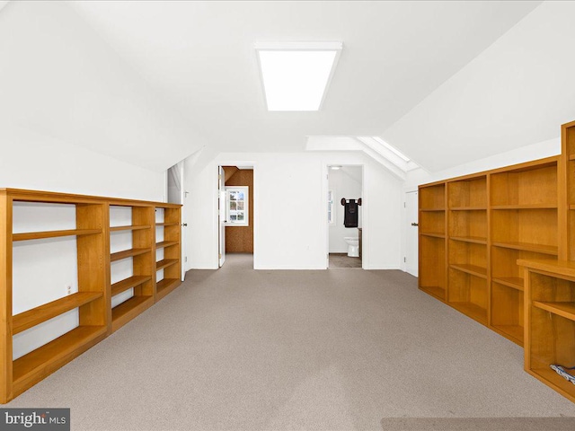 additional living space featuring dark colored carpet and lofted ceiling