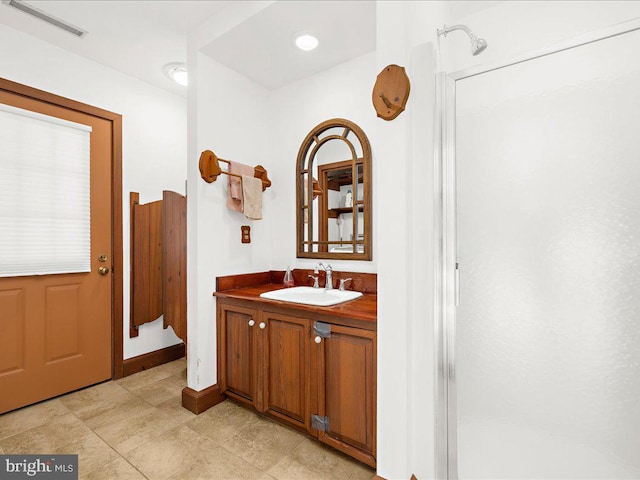 bathroom featuring vanity and an enclosed shower