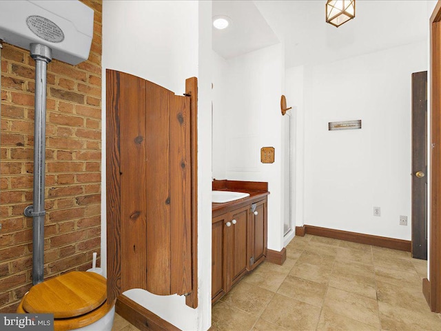 bathroom featuring vanity and brick wall