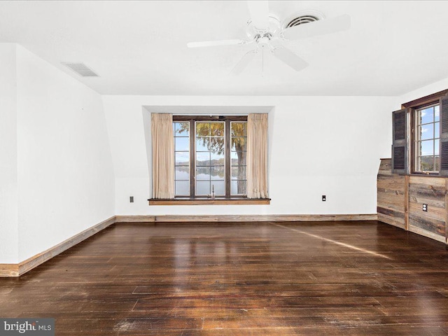 unfurnished living room featuring ceiling fan and dark hardwood / wood-style flooring