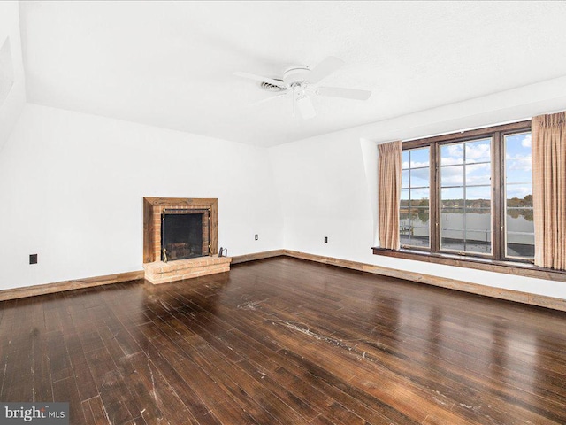 unfurnished living room with wood-type flooring, a brick fireplace, and ceiling fan