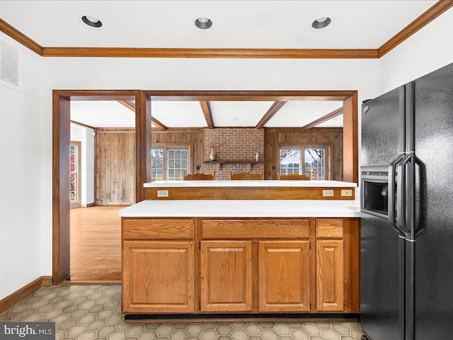 kitchen featuring kitchen peninsula, black fridge, and ornamental molding