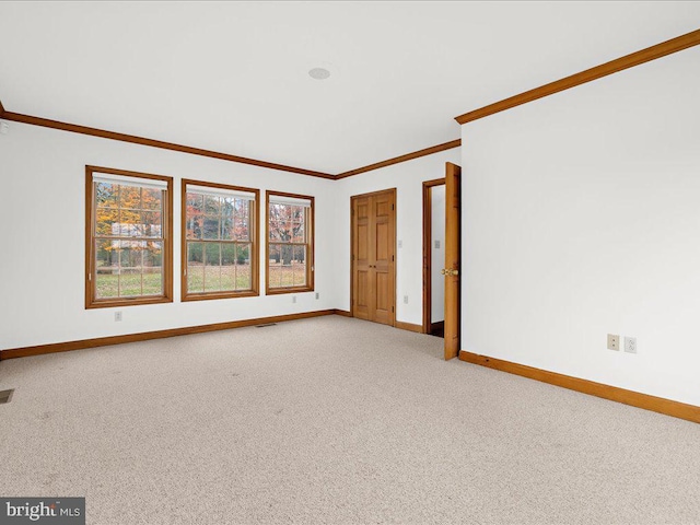 unfurnished room with carpet and crown molding