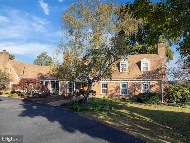 new england style home with a front lawn