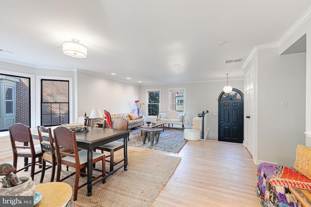 dining space with light wood-type flooring and ornamental molding