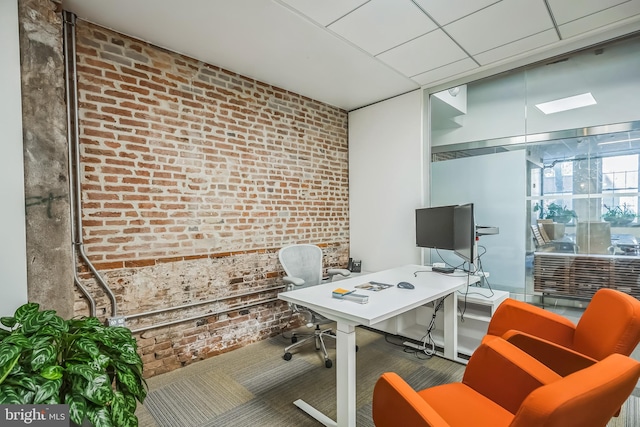 office area with carpet and brick wall