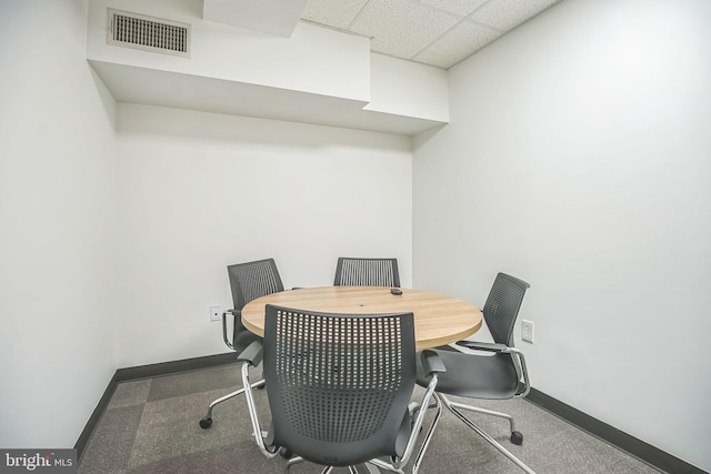 home office with a paneled ceiling and carpet