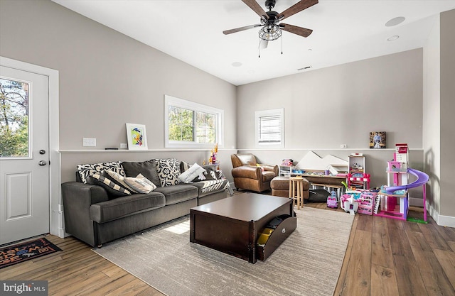 living room featuring ceiling fan and hardwood / wood-style flooring