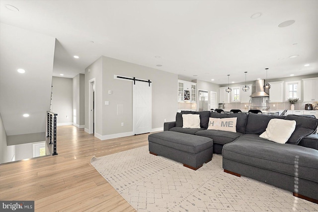 living room featuring light wood-type flooring and a barn door