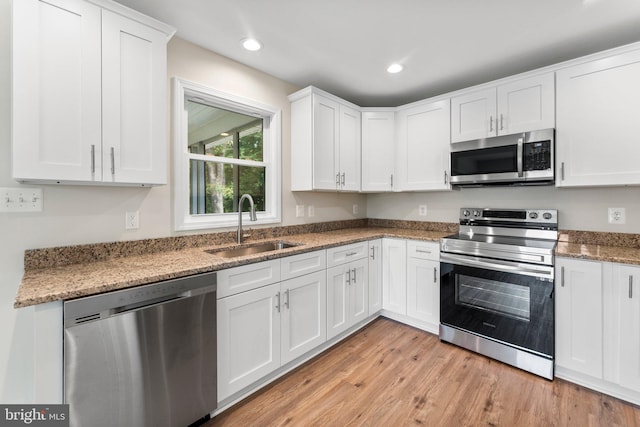 kitchen with white cabinetry, sink, stainless steel appliances, and stone counters