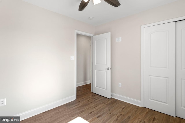 unfurnished bedroom featuring ceiling fan, hardwood / wood-style floors, and a closet