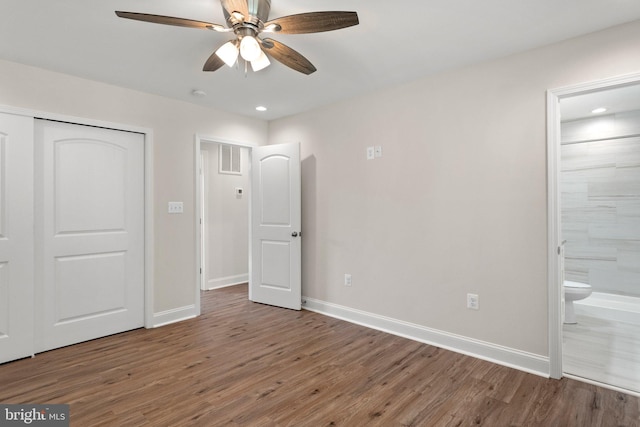 unfurnished bedroom with ensuite bath, ceiling fan, and hardwood / wood-style flooring