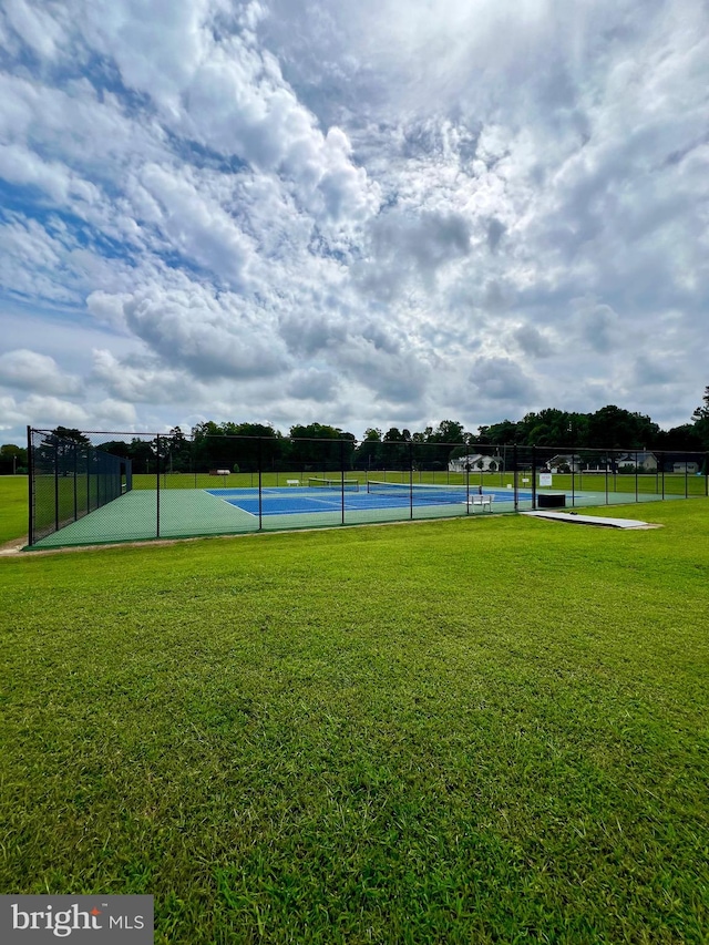 view of community with a yard and tennis court